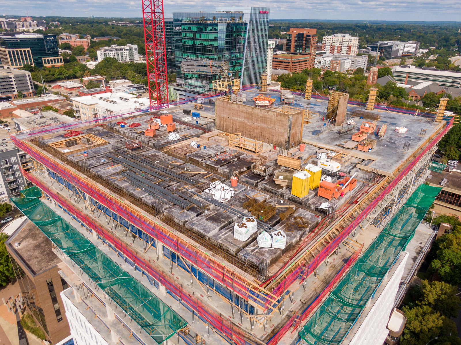 Active construction site rooftop with exposed work areas, scaffolding, and equipment highlighting common OSHA safety and inspection compliance issues