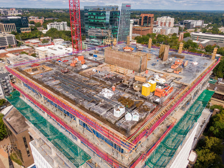 Active construction site rooftop with exposed work areas, scaffolding, and equipment highlighting common OSHA safety and inspection compliance issues