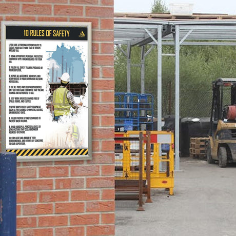 GotSafety 10 Rules of Safety poster mounted on a brick wall at an outdoor construction site with a forklift in the background — laminated 24x32 workplace safety poster